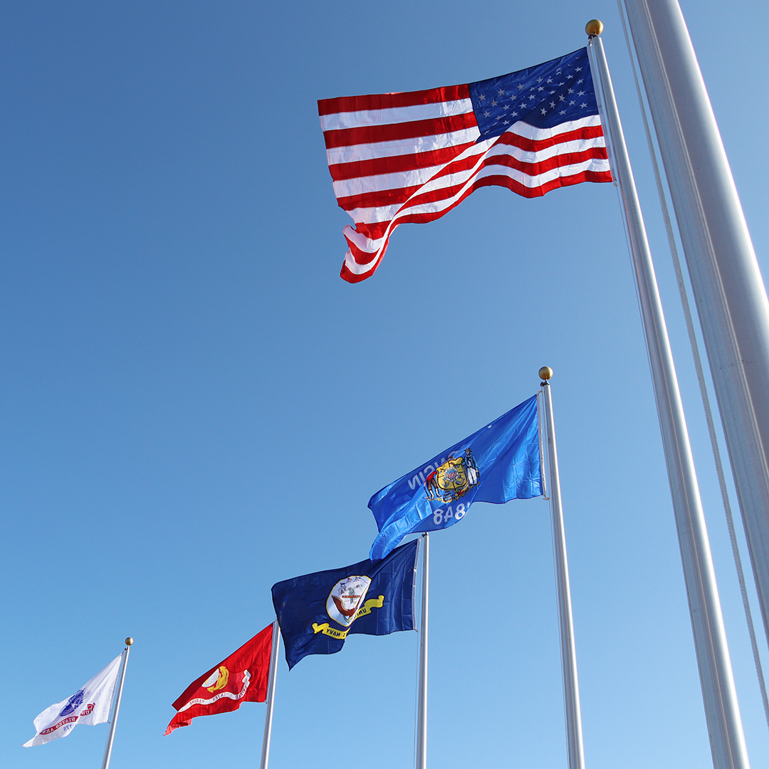 Old Glory flies high alongside service flags at memorial